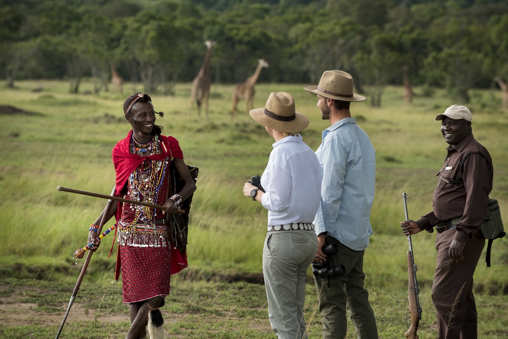 A couple of visitors on a nature walk with a Masai guide.