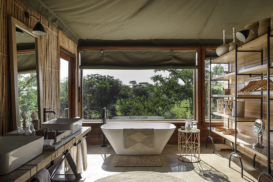 A luxury bathtub and view out the window at the Singita Faru Faru lodge