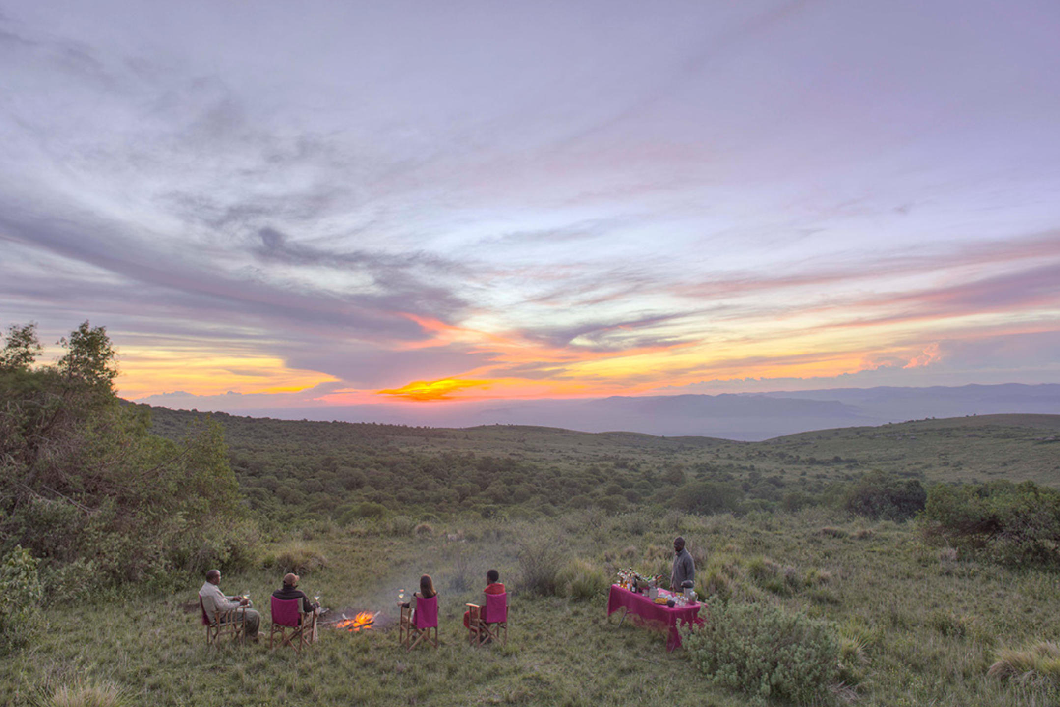 A safari group enjoying a campfire at dusk in the Ngorongoro Crater