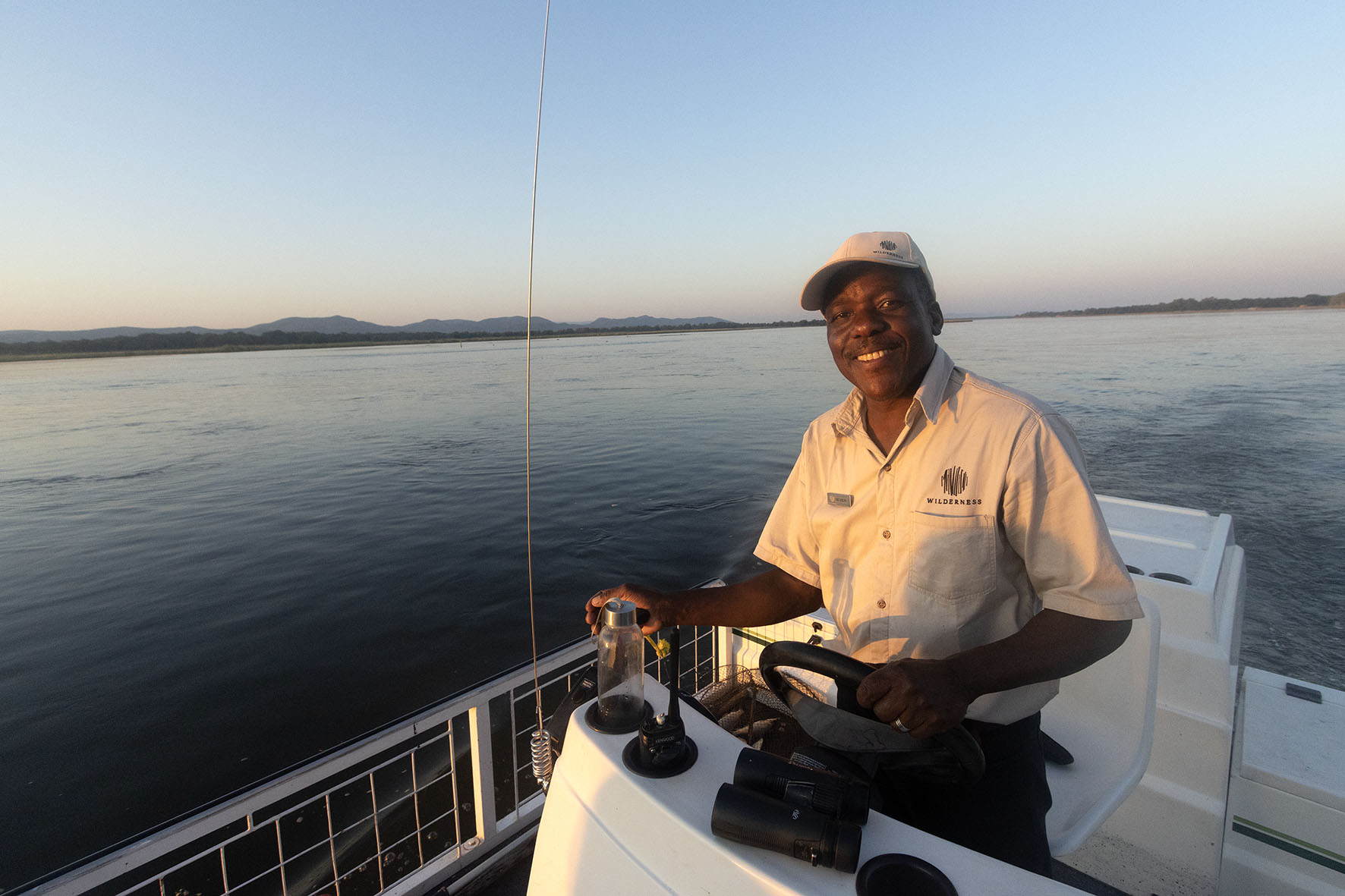 A fishing guide driving the boat while visiting Chikwenya