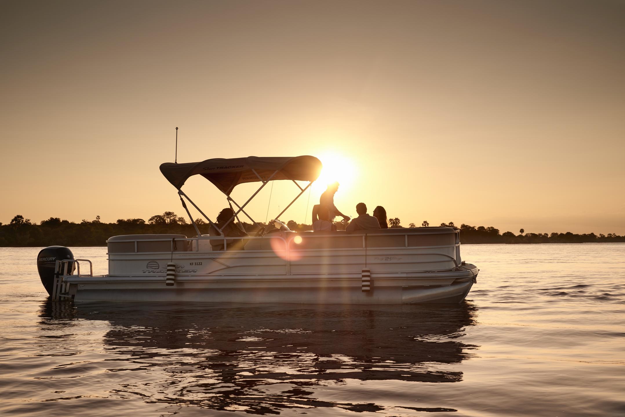 pontoon boat foating while on safari near sunset