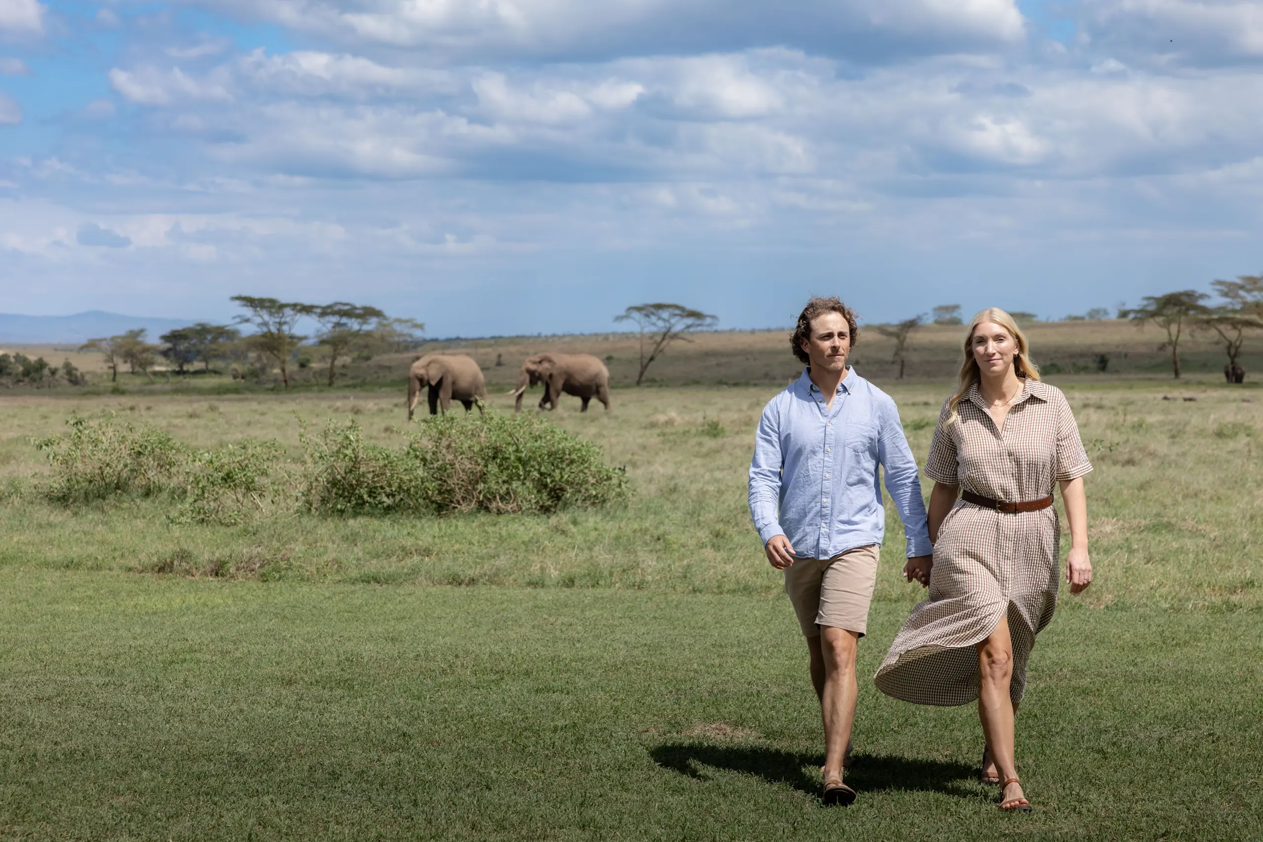 Ubuntu Travel Co-founders Kyle & Leah Green at Segera Retreat with elephants behind them. Laikipia Plateau, Kenya 